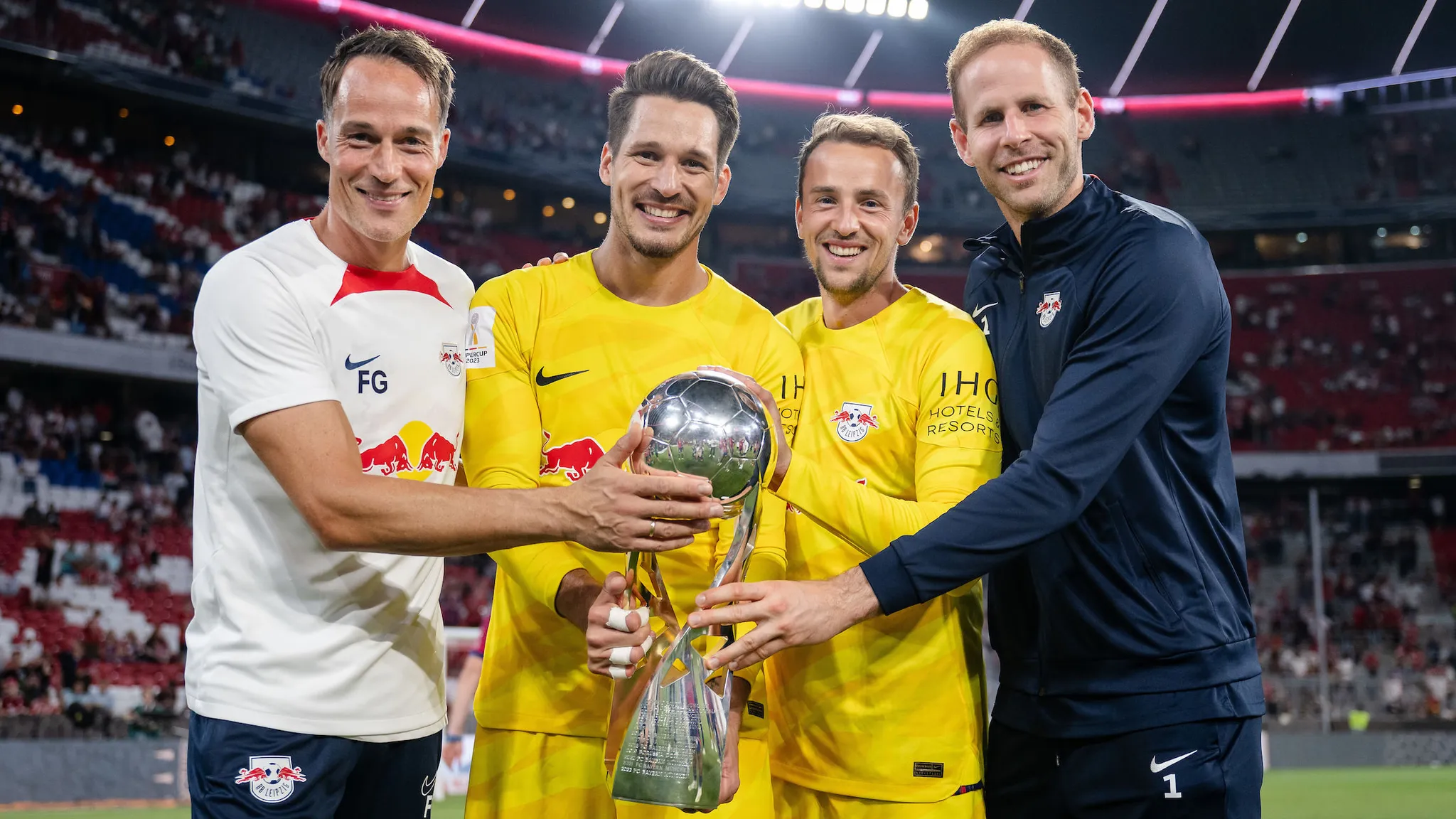 Leipzigs Torwarttrainer Frederik Goessling, Janis Blaswich, Leopold Zingerle und Peter Gulacsi posieren mit der Supercup-Trophäe.