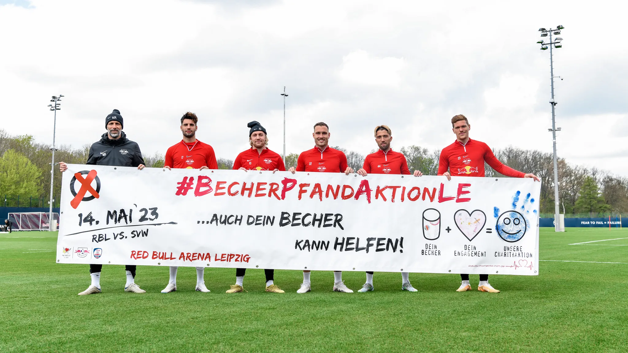 Spieler von RB Leipzig halten ein Plakat zur Becherpfandaktion hoch.